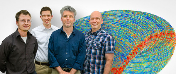 4 members of the Computational Cosmology Center pose in front of a visualization
