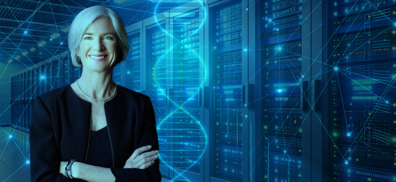 Woman in black jacket and pearls stands cross-armed in the foreground with an illustration composed of dots, lines, and computer cabinets in the background.