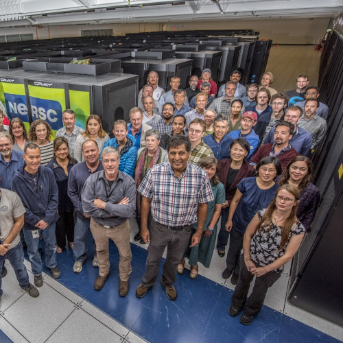 About 50 smiling NERSC staff and the now-retired Cori supercomputer in 2017.